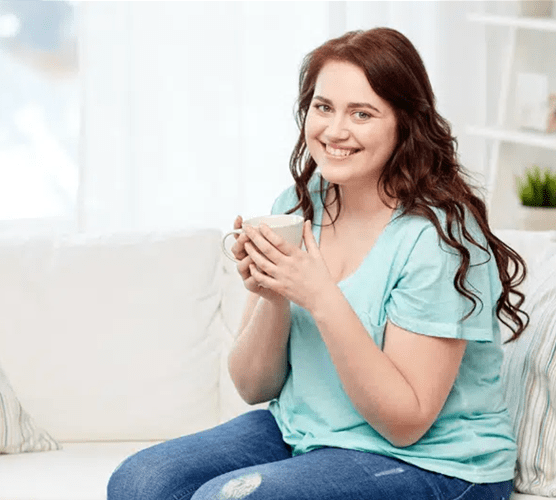 Woman enjoying a warm drink from a mug after bariatric surgery in Tijuana, Mexico.